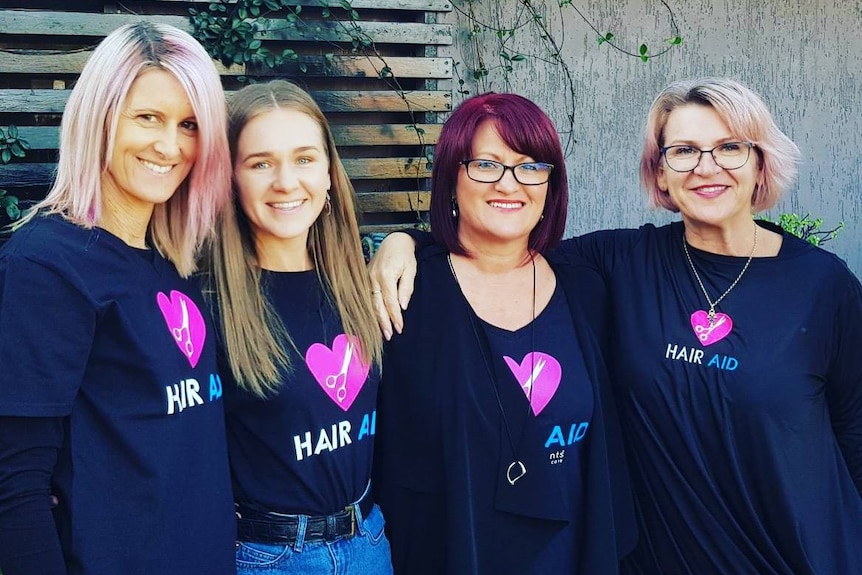 Bronwyn Ball and Selina Tomasich with other members of the Hair Aid team.