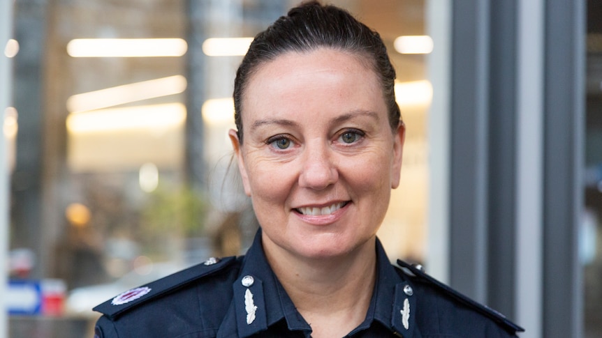 Lauren Callaway, who has dark hair pulled back and is wearing a navy Victoria Police uniform, poses for a photo