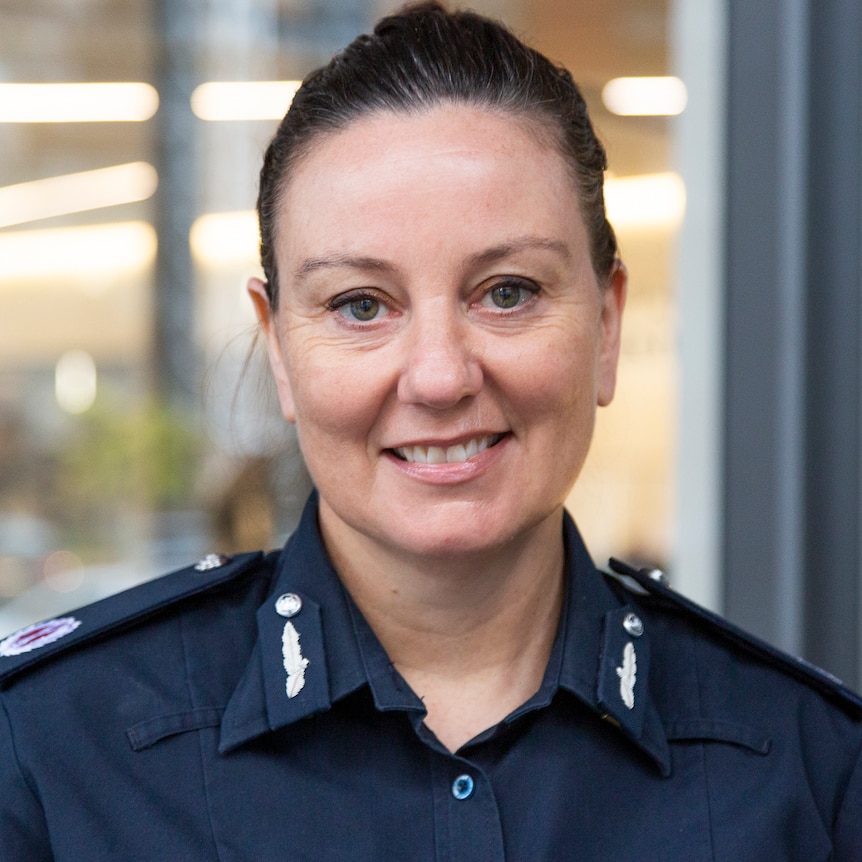 Lauren Callaway, who has dark hair pulled back and is wearing a navy Victoria Police uniform, poses for a photo