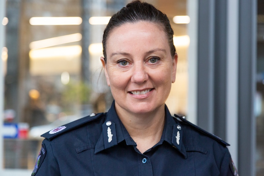 Lauren Callaway, who has dark hair pulled back and is wearing a navy Victoria Police uniform, poses for a photo