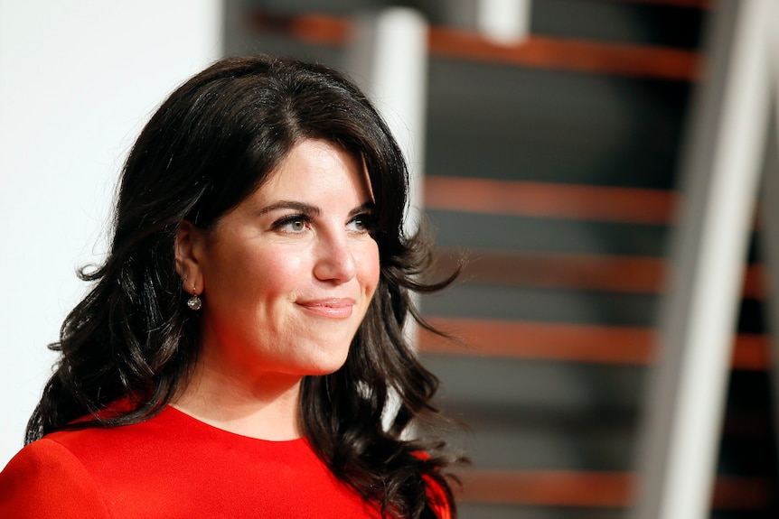 Monica Lewinsky in a red dress and smiling.