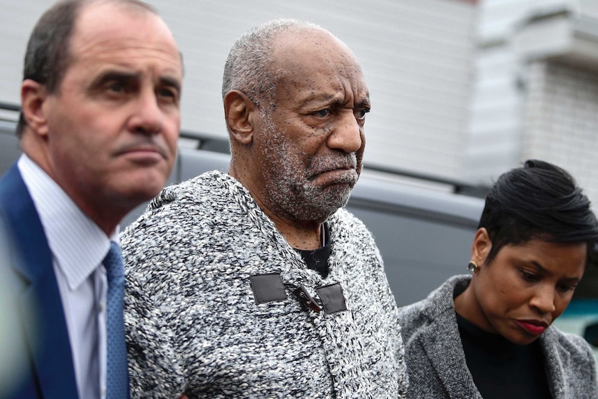 Bill Cosby arrives at court with someone either side of him.