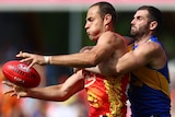 Jarrod Witts tackled by Jack Darling during an AFL match on the Gold Coast.