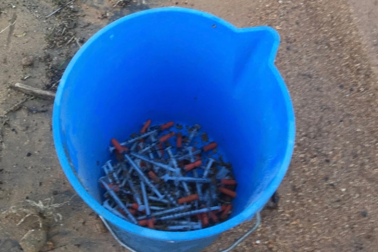 Bucket full on syringes on the sand at Lake Hume.