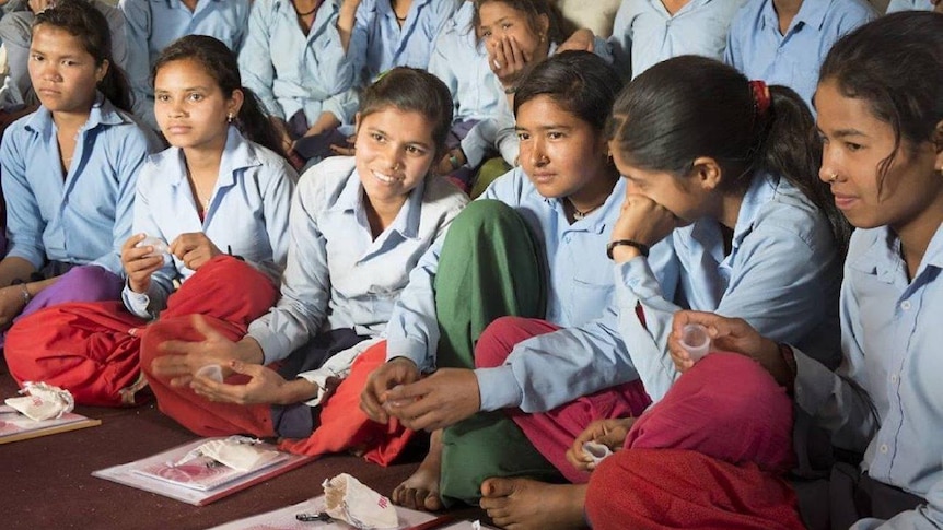 School girls sit with their cups