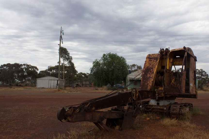 A lone digger stands at the entrance to Ora Banda.