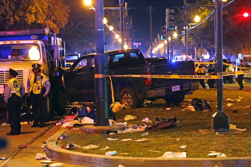 Police stand next to a pickup truck that slammed into a crowd in New Orleans.