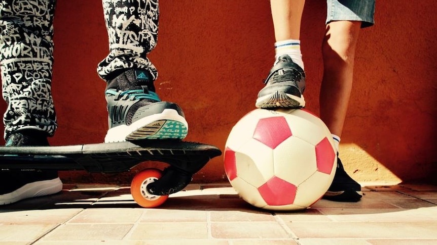 Photo of a child with a soccer ball and a child with a skateboard 
