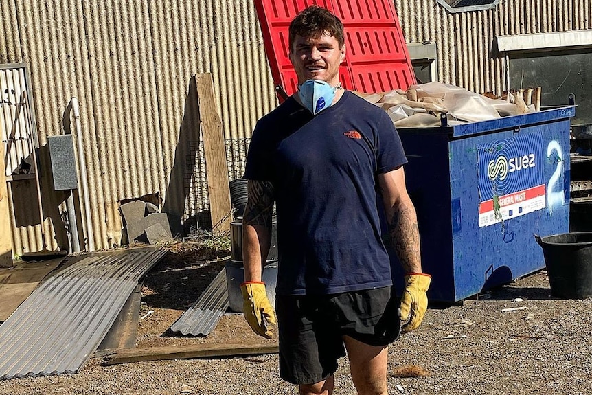 A Canberra Raiders NRL player poses for a photograph while working as a tradesperson
