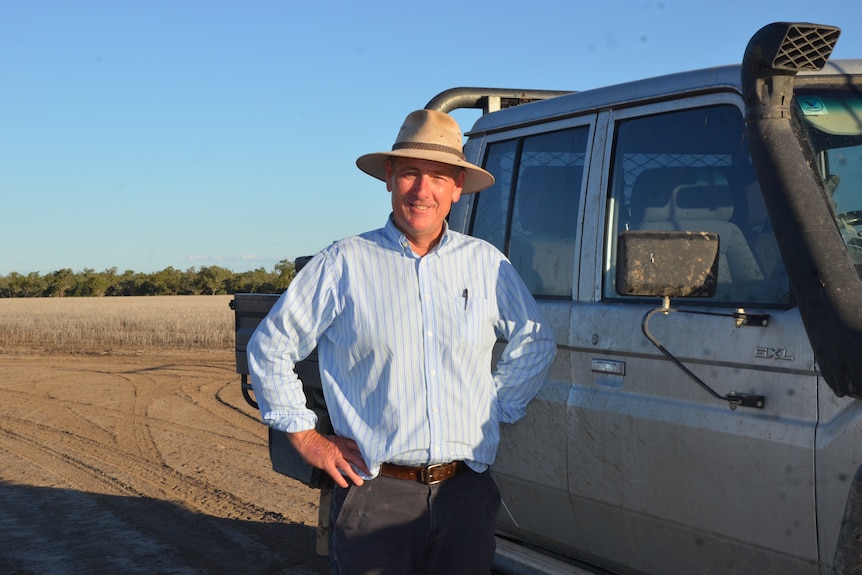 Greg Rummery stands next to his ute on his property. 