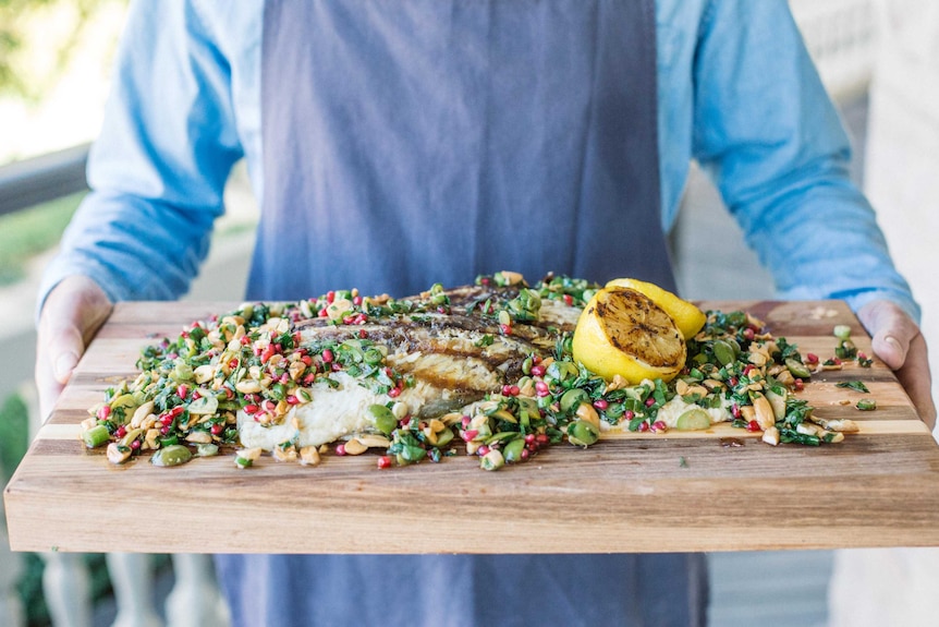 A whole barramundi cooked on a BBQ