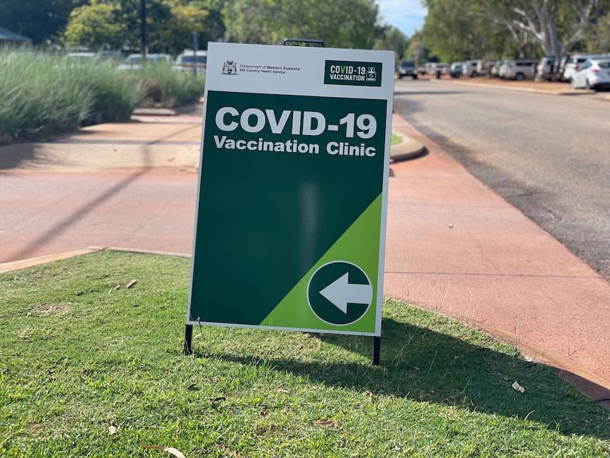 Image of a green sign pointing to a COVID vaccination centre at Broome Hospital.