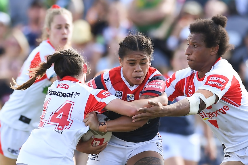 Sarah Togatuki grimaces as she crashes through two tacklers