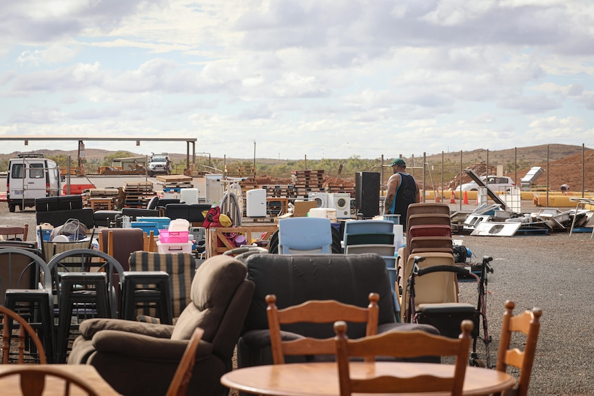 A man in the background looking at a collection of furniture and random goods at Karratha's tip shop.