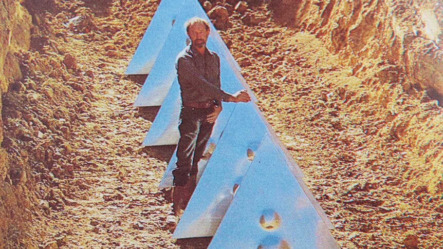 The artist stands next to his tetrahedrons, 4.5 metres below the topsoil.