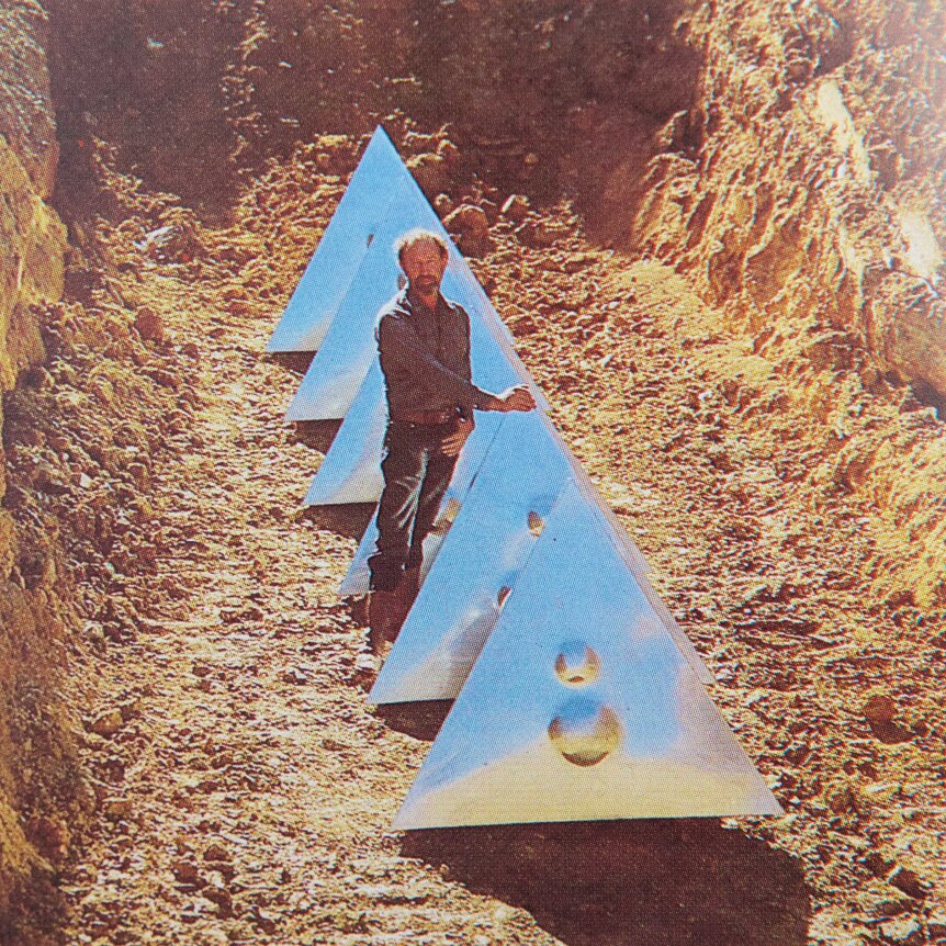 The artist stands next to his tetrahedrons, 4.5 metres below the topsoil.