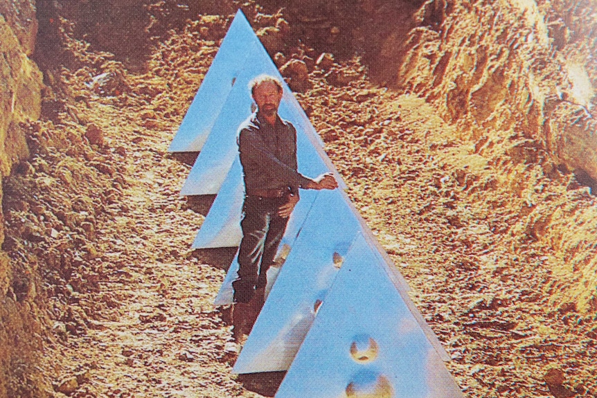 The artist stands next to his tetrahedrons, 4.5 metres below the topsoil.