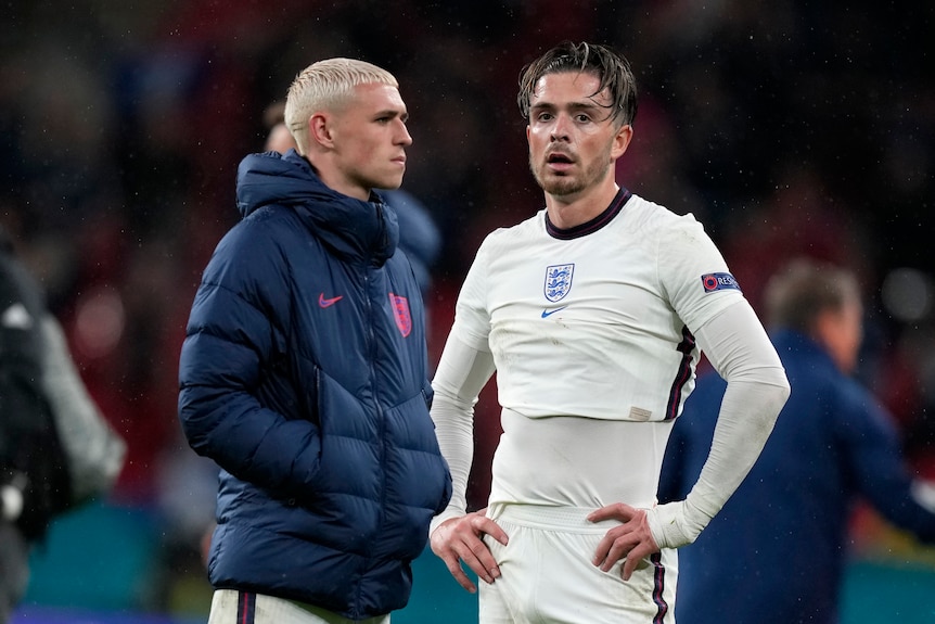 Phil Foden and Jack Grealish stand next to each other