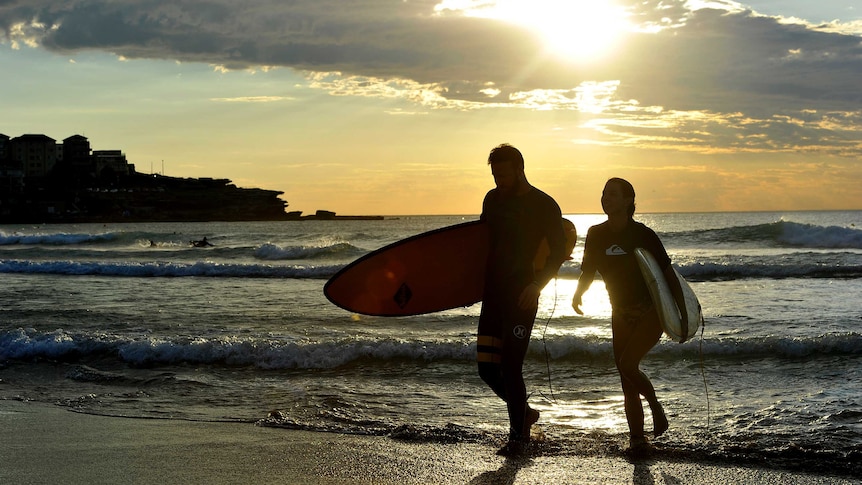 Couple with surfboards at beach