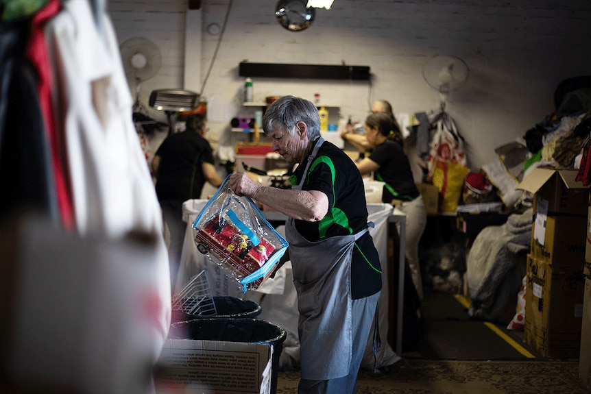 a group of women sort through second-hand goods