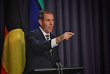 Jim Chalmers pointing during a press conference. 