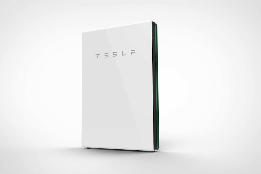 A square brick-like battery with the tesla logo