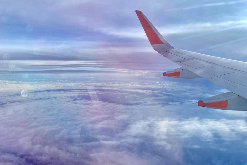 Clouds swirl under the wing of a plane.