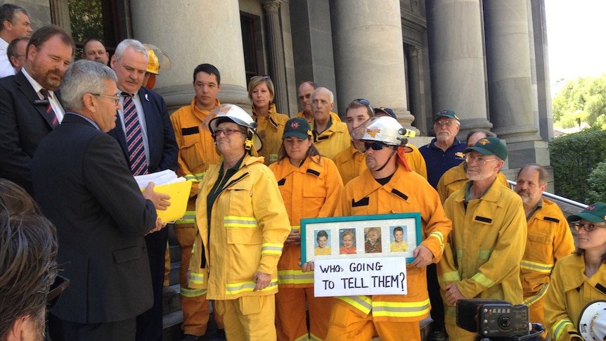 Country Fire Service firefighters deliver a petition on the steps of the South Australian Parliament.