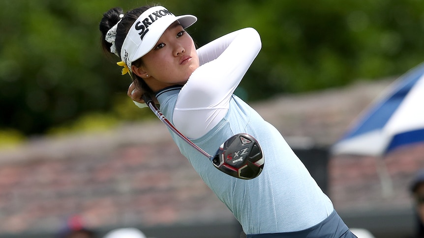 An Australian female golfer hits a shot with a club during a tournament in Brisbane.