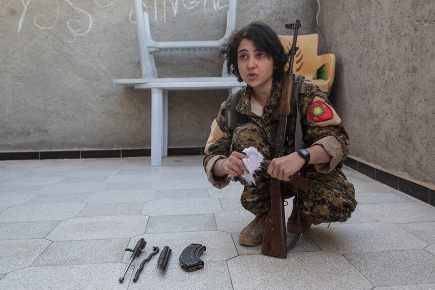 A German girl of a Yazidi family with her gun