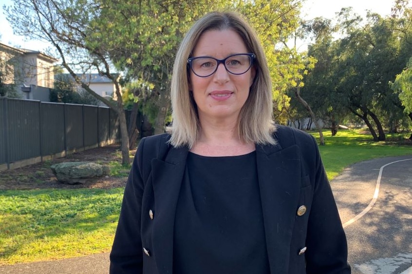 Deakin University public health professor Samantha Thomas stands in a park wearing a black blazer.