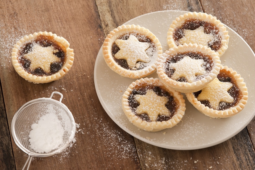 A plate of fresh fruit mince pies with a star pattern on top.