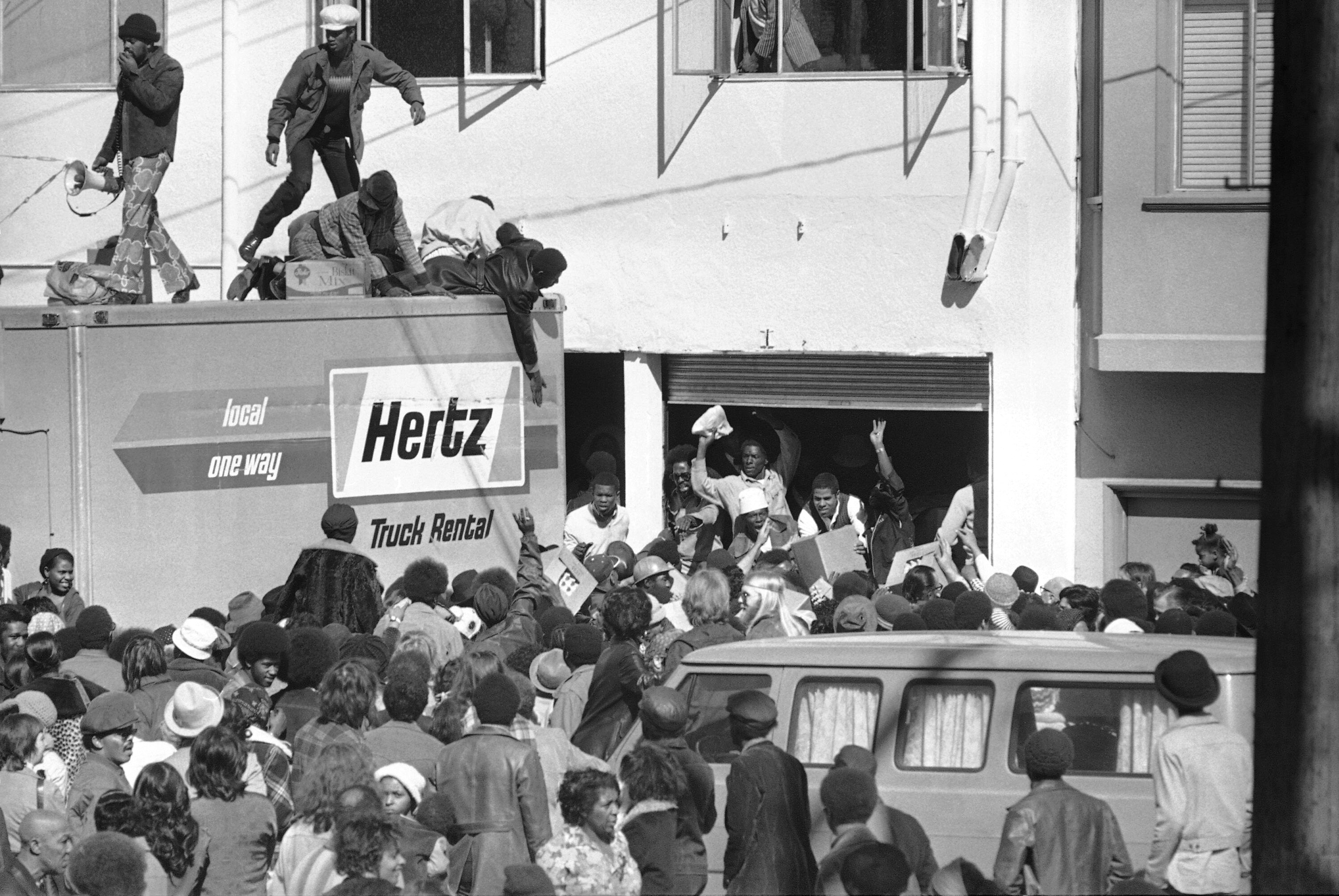A group of people converging on a truck