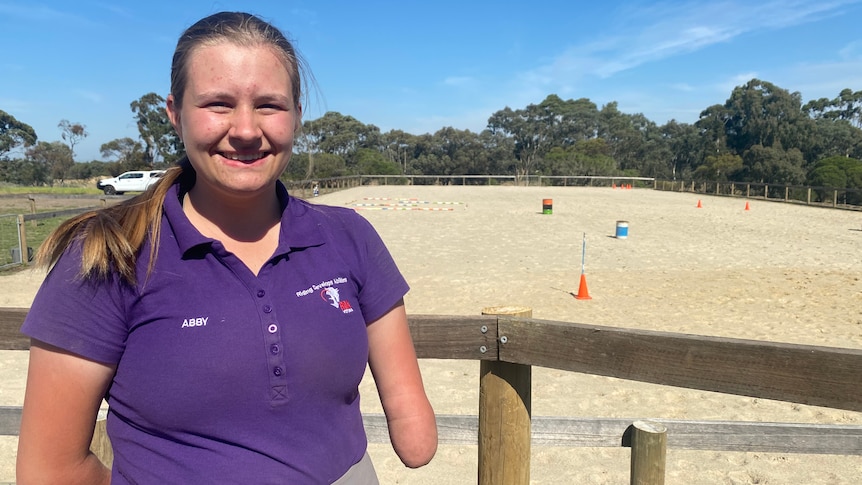 Abby Vidler, a 17-year-old with no forearms, smiles happily at the camera.