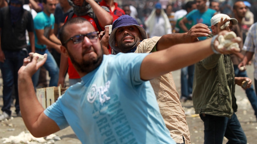 Egyptian anti-military protesters throw stones during clashes with unidentified attackers in Cairo.