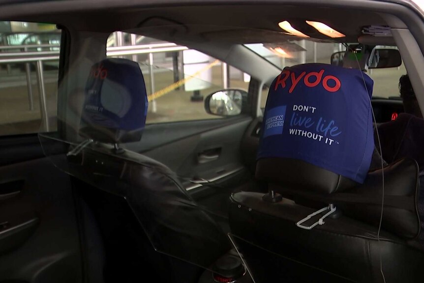 the interior of a car with a glass pane dividing the back and front seats