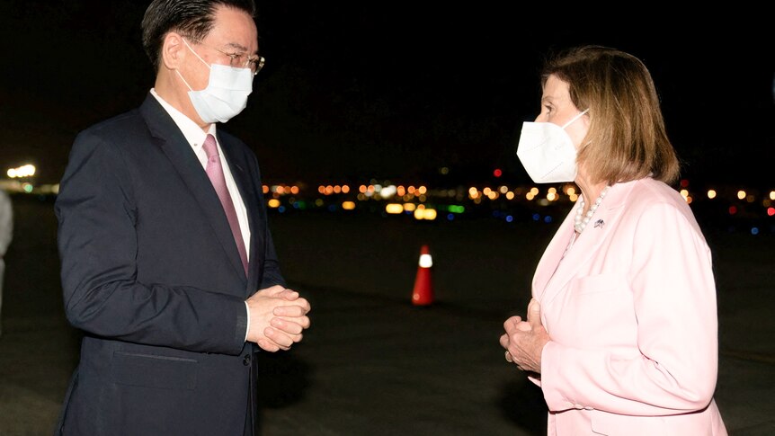Taiwan Foreign Minister Joseph Wu dressed in a suit and wearing a mask welcomes Nancy Pelosi wearing a pink suit and mask.