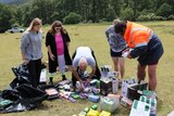 Five campers sort through food supplies on the ground.