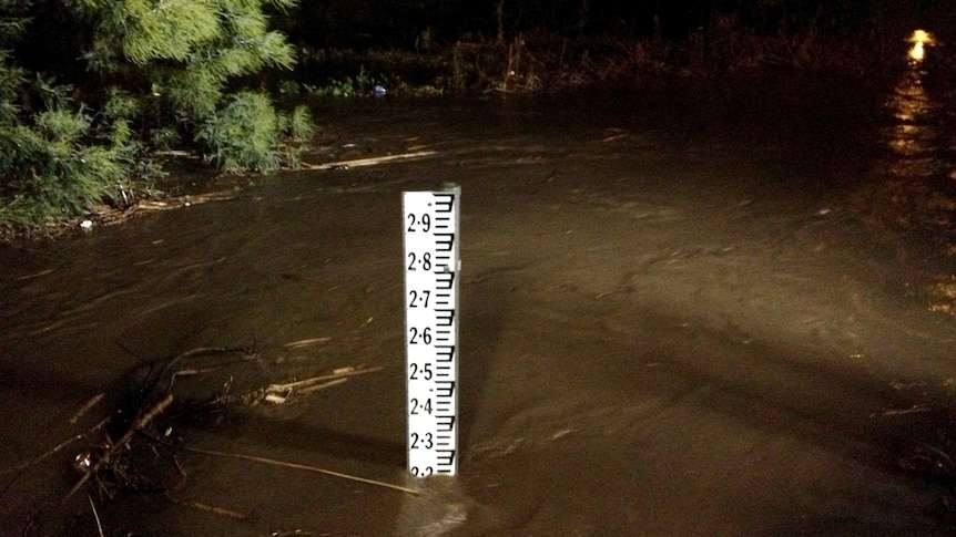 Floodwaters flow around a flood marker at Traralgon.