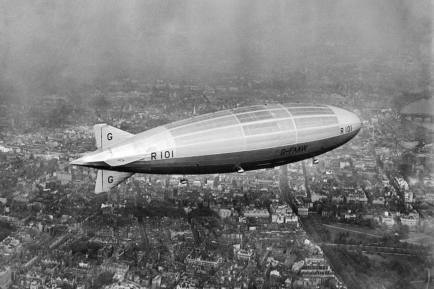A black and white image of the R101 airship flying over London.