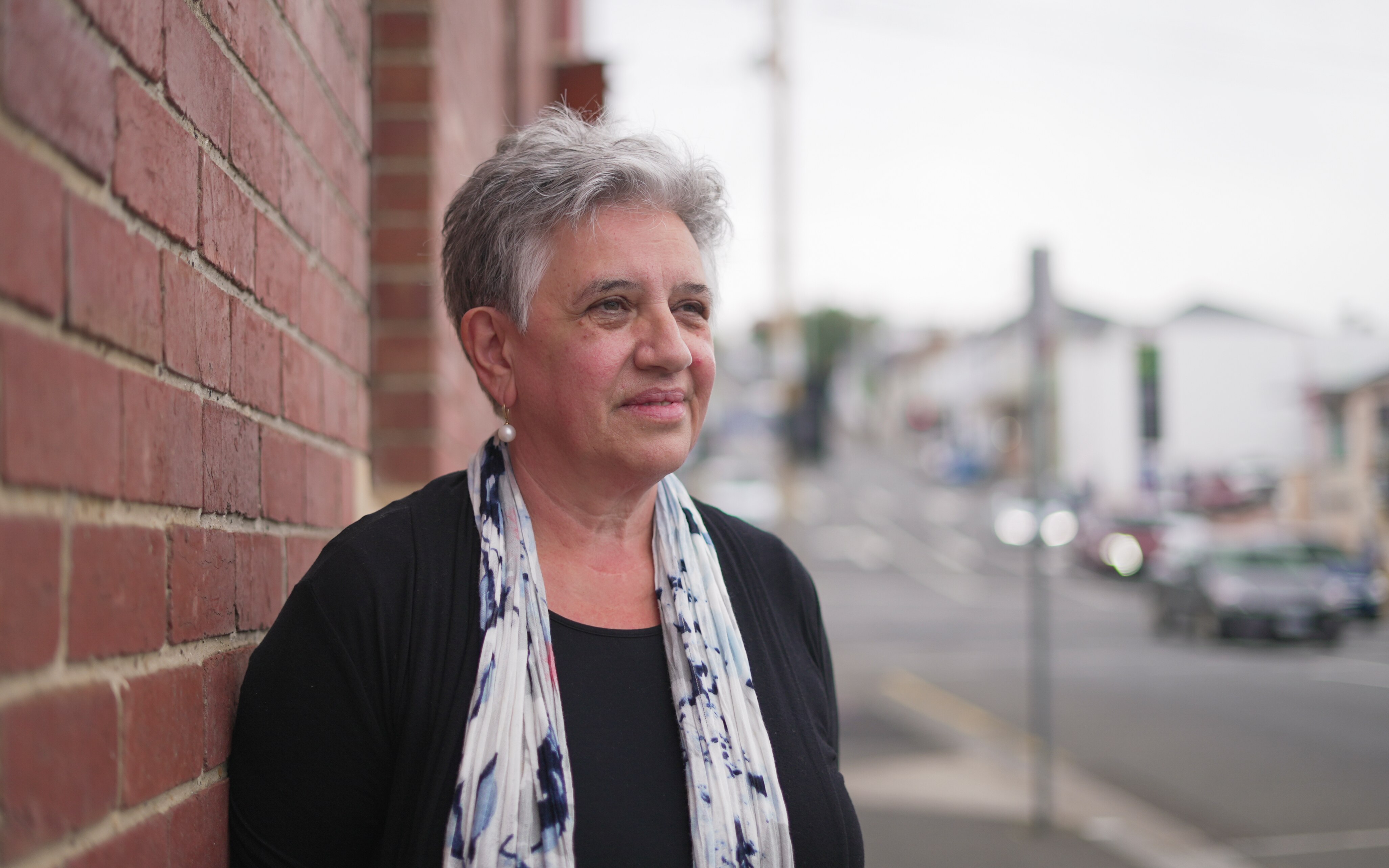 A middle-aged woman stands on a street