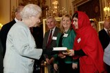 Malala Yousafzai gives a copy of her book to Queen Elizabeth II