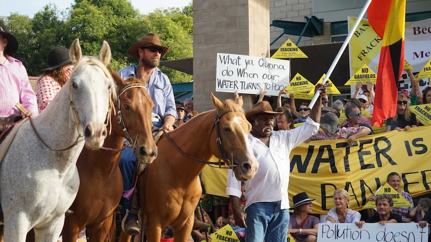 A man on a horse is pictured among a crowd of protestors