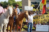 A man on a horse is pictured among a crowd of protestors