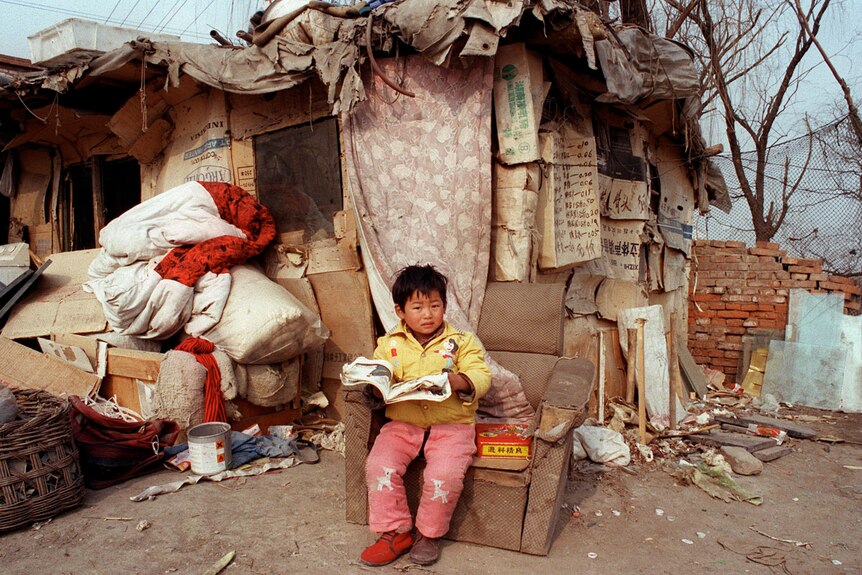 A boy in the shanty town were his family lives, only 15 minutes walk from one of Beijing's international four-star hotels