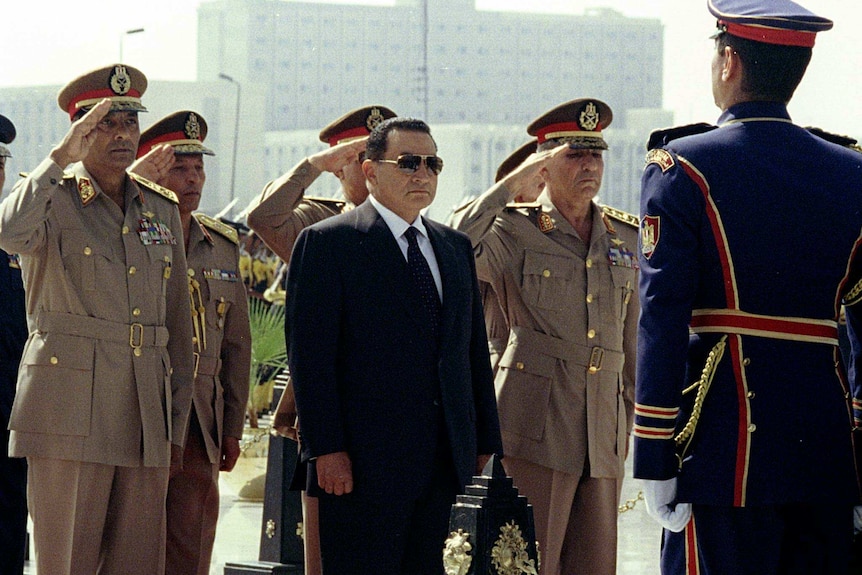 Hosni Mubarak is flanked by military officials.