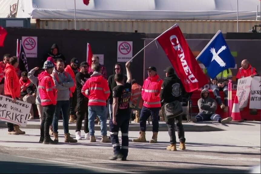 Union members waving CFMEU flags.