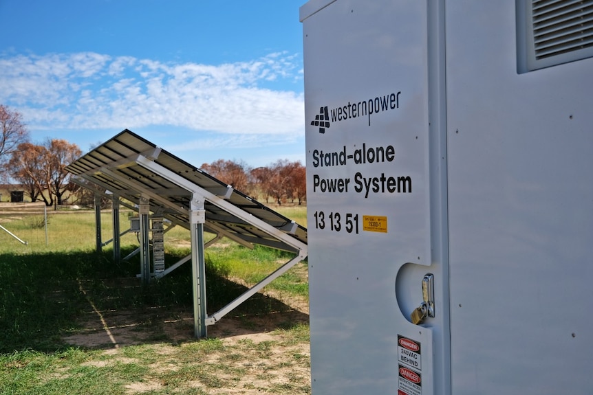 A big white box and solar panel in a field