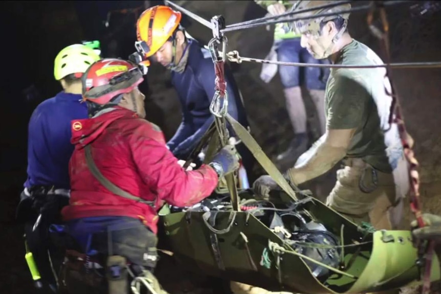 Rescuers hold an evacuated boy inside the Tham Luang cave.