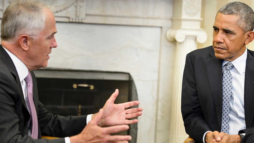 Barack Obama listens to Malcolm Turnbull, gesturing with both hands, during a meeting in the Oval Office.